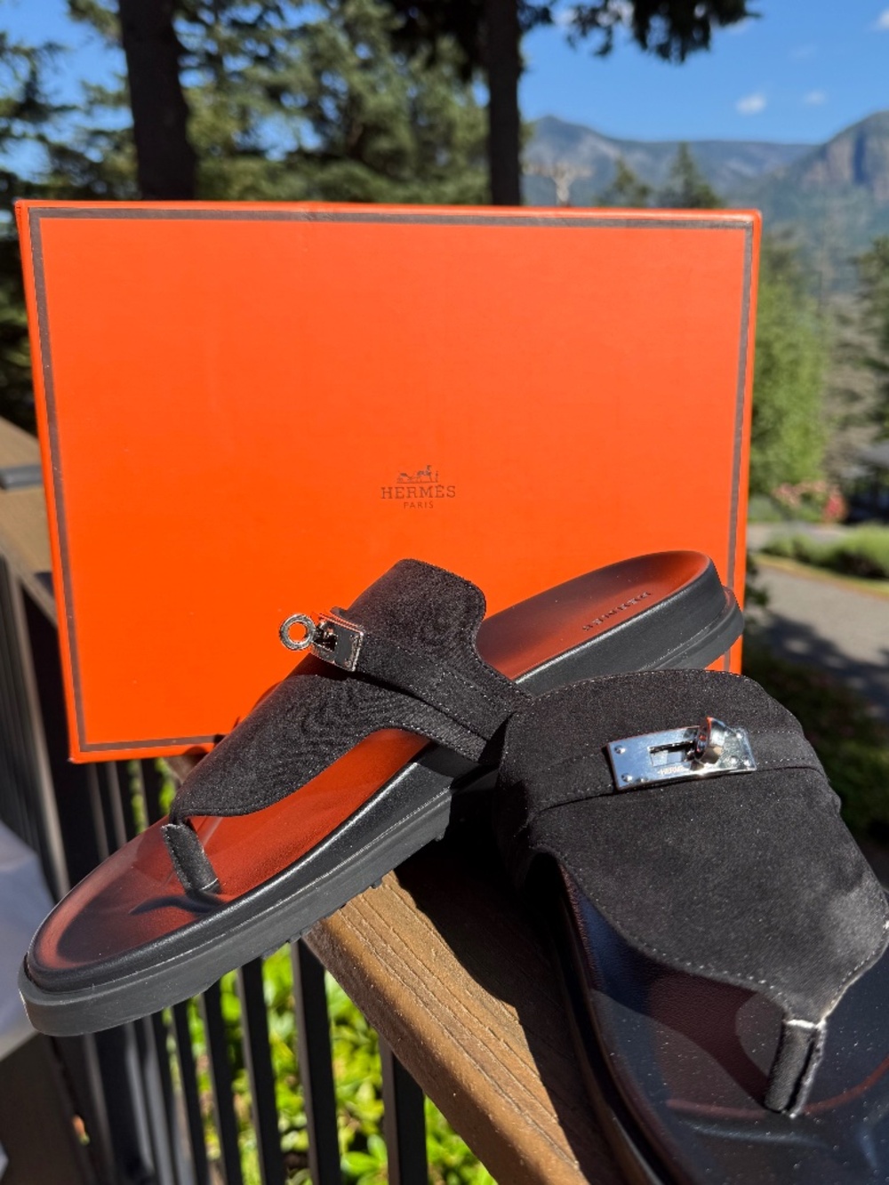 Black suede Empire sandals with a distinctive "Kelly" buckle